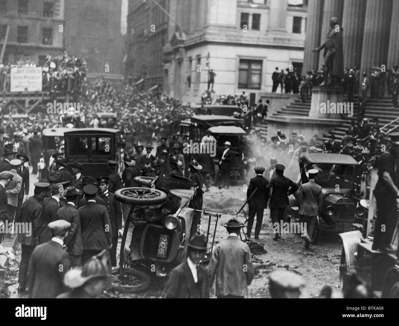 The Wall Street Bombing. Overturned automobile, smoke, and debris from explosion in front of a Federal Hall at Broad and Wall streets in New York City on September 16, 1920. 38 were killed and 300 injured. Stock Photo