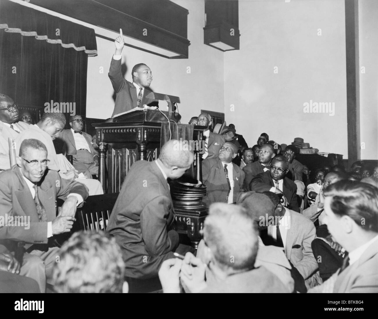 Rev. Martin Luther King, Jr., speaking at a meeting of the Montgomery Improvement Association, the organization form after Rosa Parks was arrested for not moving to the back of the bus. Earlier, King, then, only 27 years old, was elected the organization's leader. 1956. Stock Photo