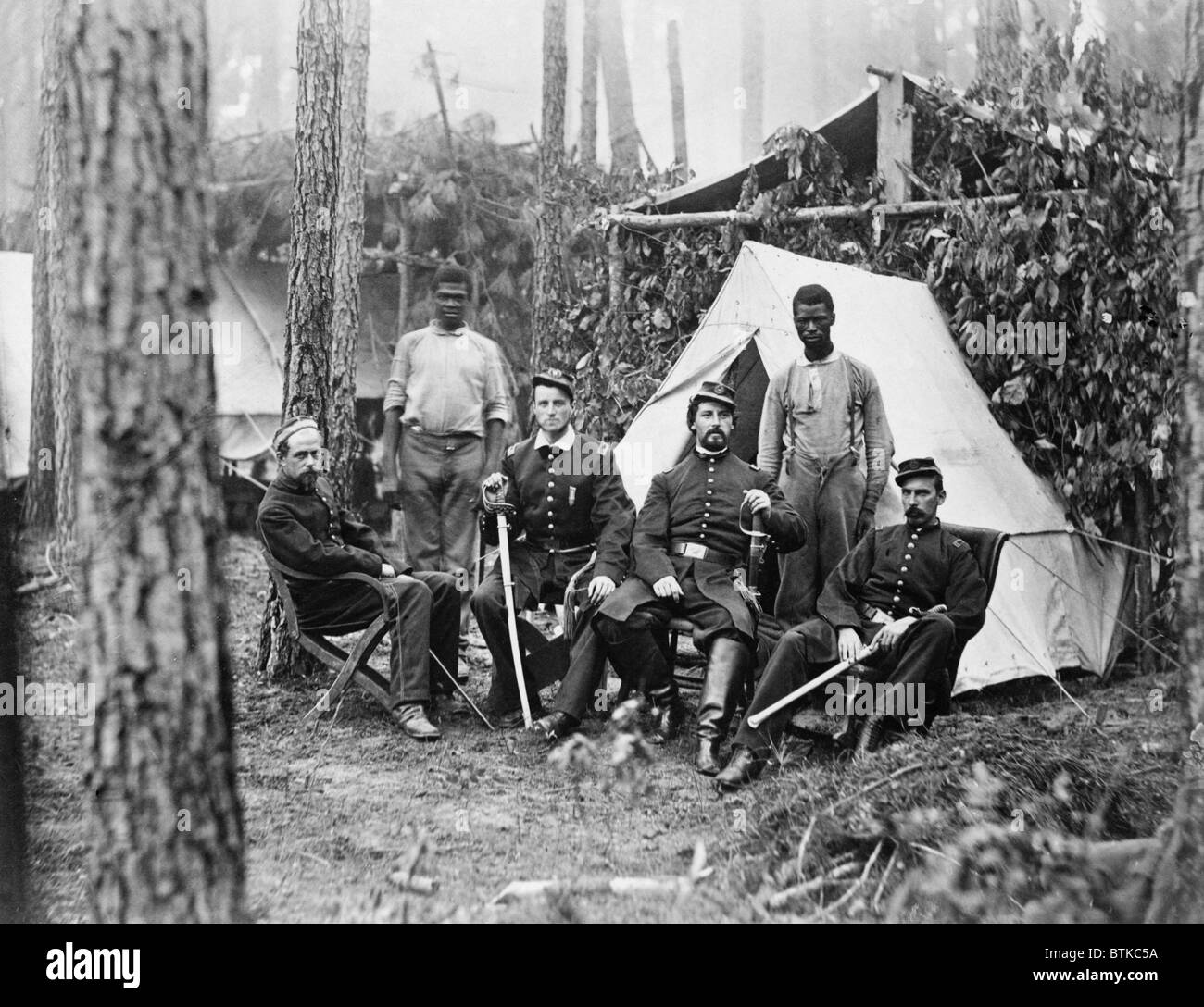 Four union officers in front of tent, with two Africans-American during the Petersburg Campaign of the last year of the war. Many former slaves, emancipated in 1863, were employed a servants to Union officers. August, 1864. Stock Photo