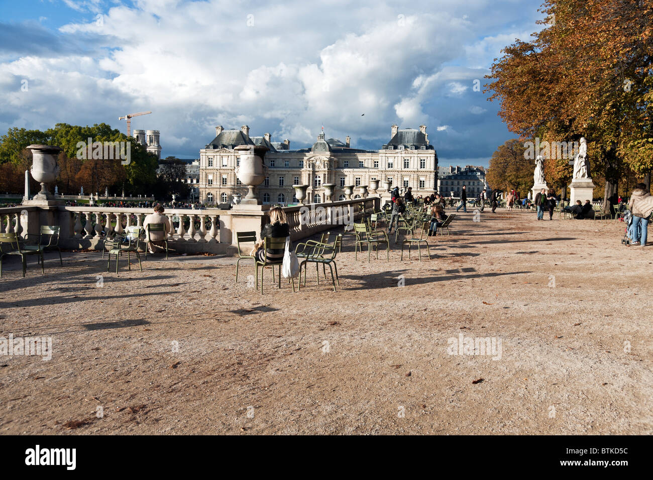 people enjoy beautiful autumn afternoon on terrace of Luxembourg Gardens with statuary urns & balustrade overlooking lower area Stock Photo