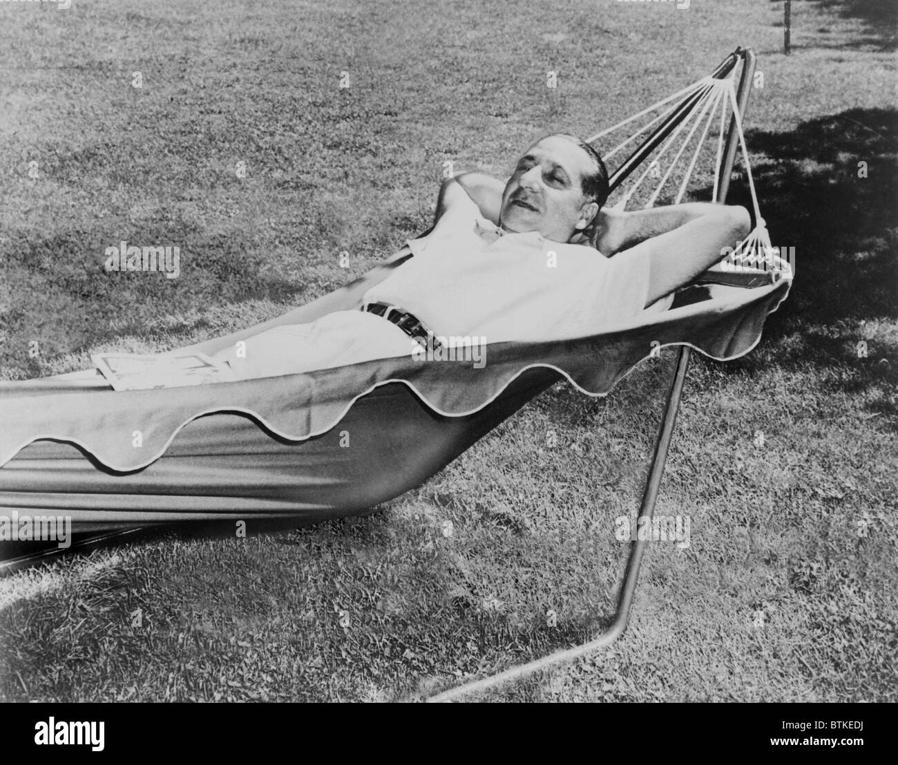Frank Costello (1891-1973), Italian born gangster and close associate of mob boss Lucky Luciano, lying in a hammock, at his estate at Sands Point in 1950. Stock Photo