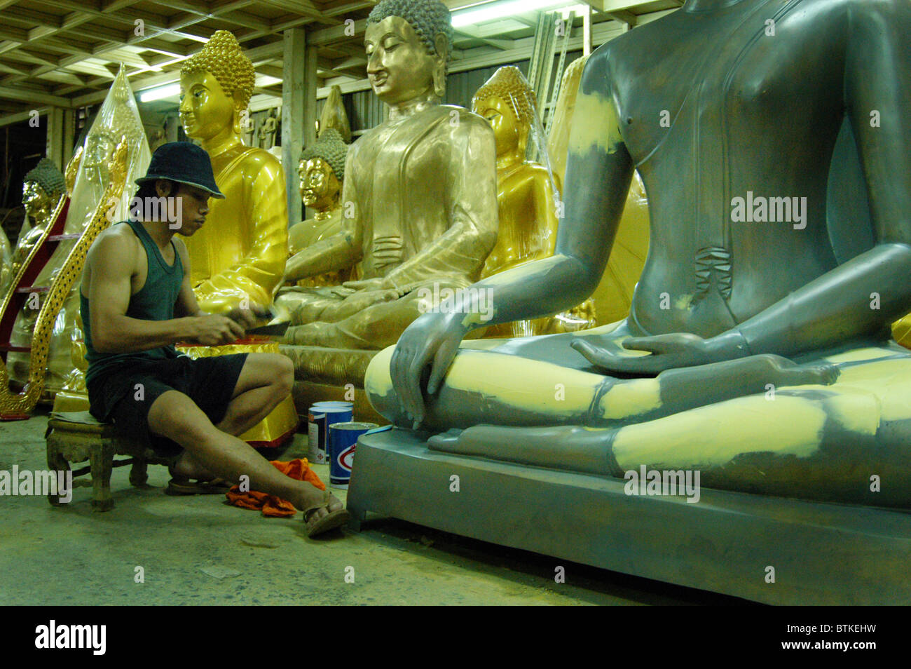 Boy works on Buddha at a  buddha workshop, Bangkok, Thailand. Stock Photo