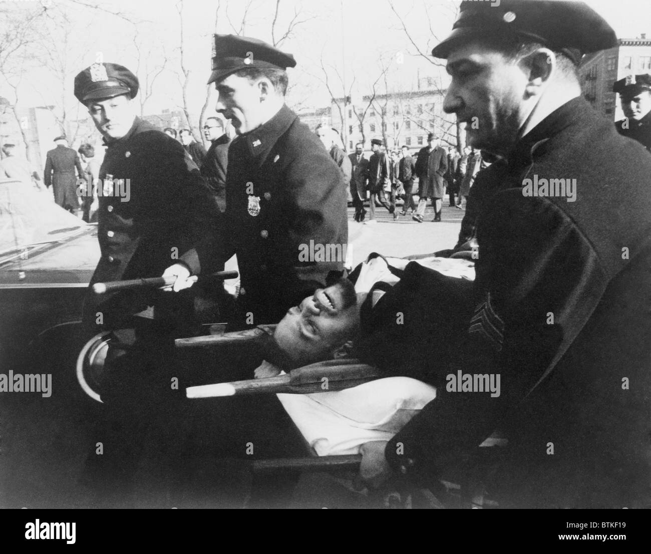 Malcolm X (1925-1965), on stretcher carried by New York policemen following his assassination at rally in a Harlem. February 21, 1965. Stock Photo