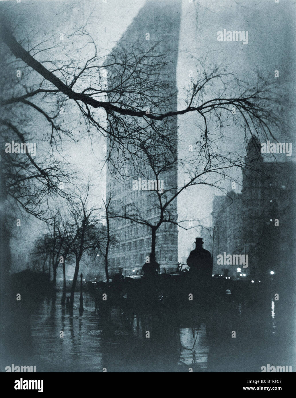 The Flatiron building, New York City, on a rainy night in pictorial photo by Edward Steichen (1879-1973), ca. 1900. Stock Photo