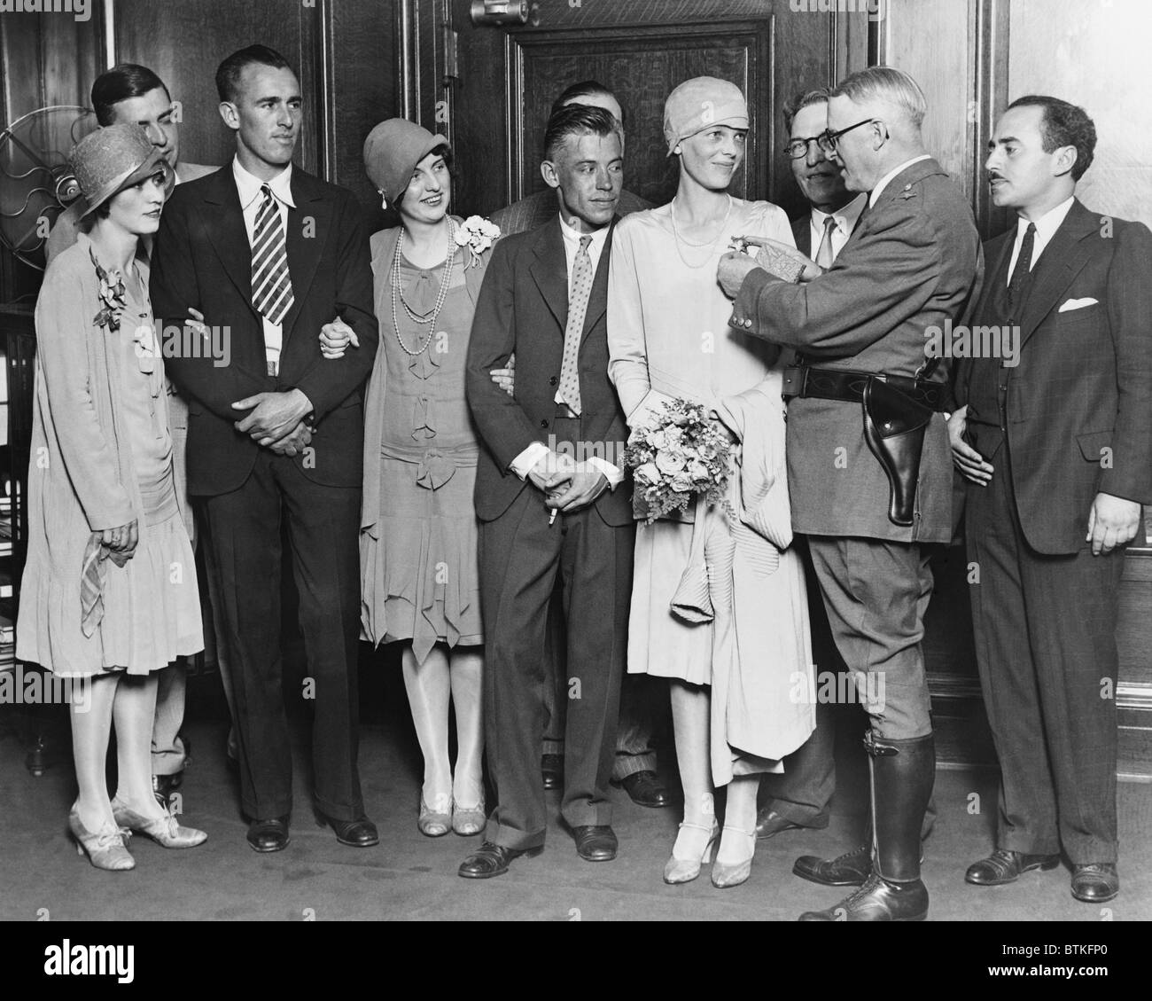 Chicago Chief of Police Michael Hughes pinning a star on Amelia Earhart on July 19, 1928. Left to right: Mrs. Stultz, Lou Gordon, Ann Bruce, Mr. Stultz, Amelia Earhart, Chief Hughes, and Acting Mayor William D. Saltiel. Stock Photo