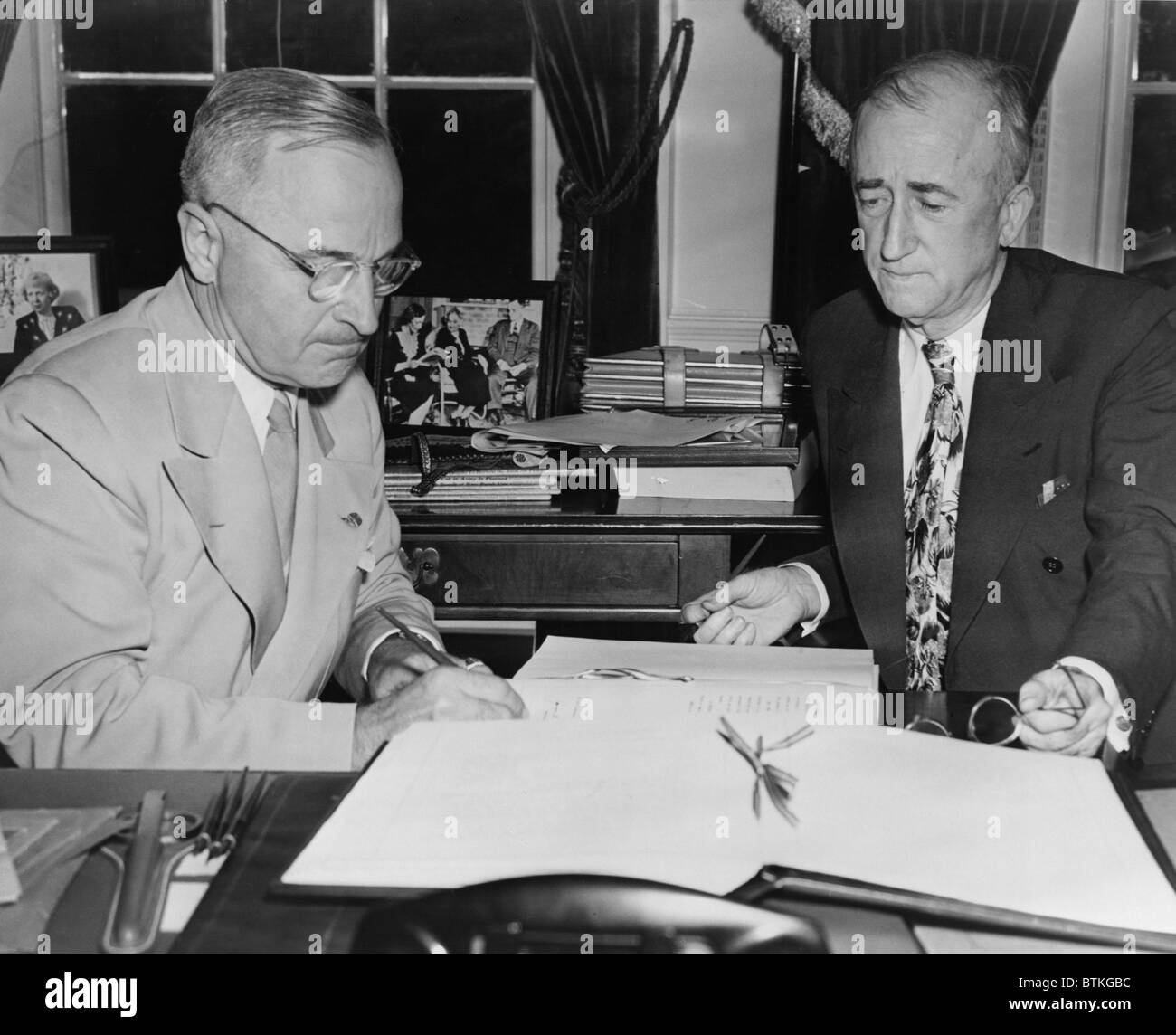 President Harry S. Truman, with Secretary of State, James F. Byrnes, signs the United Nations charter. 1945. Stock Photo