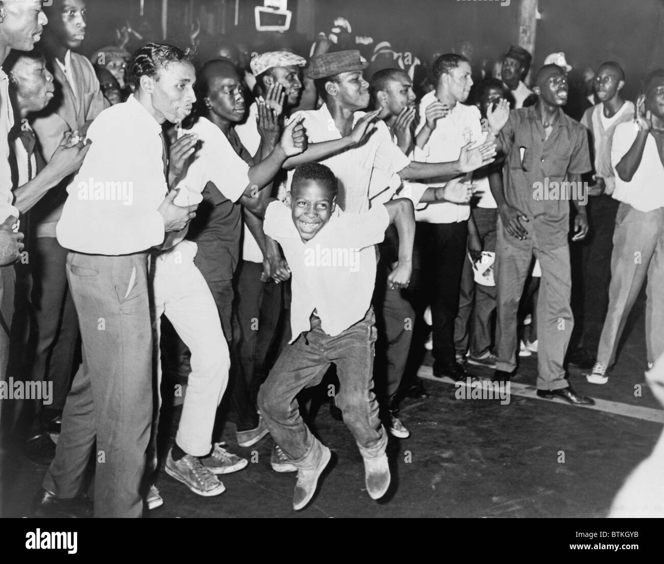 On Harlem's Lenox Avenue young African Americans chant and taunt New York City police during the riot of July 15-16, 1964. Stock Photo
