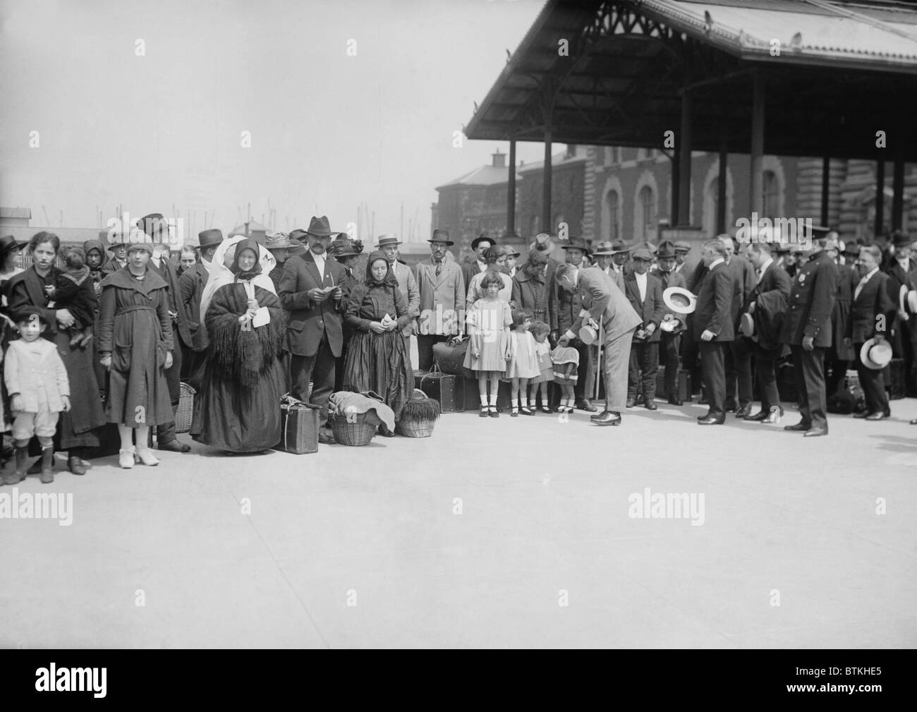 Ellis Island commissioner, Frederick Wallis posed with a group of new arrivals in 1921-21, during the end of unlimited influx of immigrants and transition to restrictions established with the 1924 Immigration Quota Act. Stock Photo