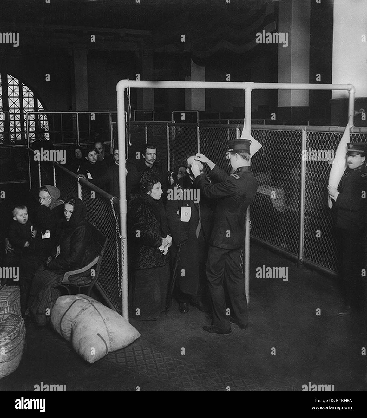 U.S. inspectors examining eyes of immigrants at Ellis Island, in New York Harbor. A diagnosis of trachoma would automatically be grounds for refusing admission to the United States. Stock Photo