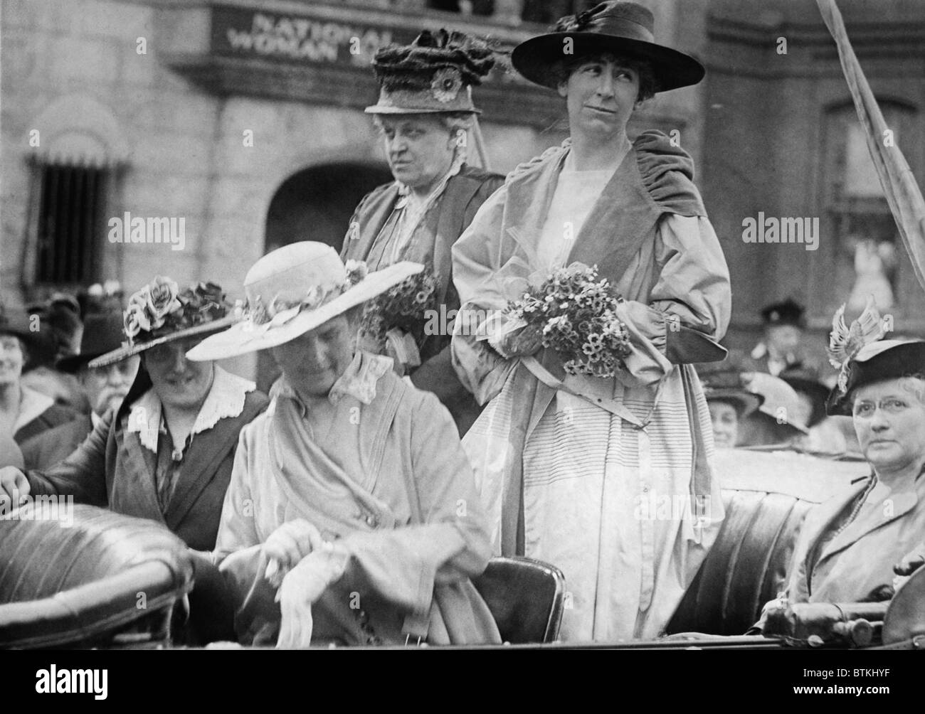 Jeannette Rankin (1880-1973), first woman member of the U.S. Congress stands in an open car in front of the Washington D.C. headquarters of the National Woman's Suffrage Association. To Rankin's right is veteran woman's rights advocate Carrie Catt. Stock Photo