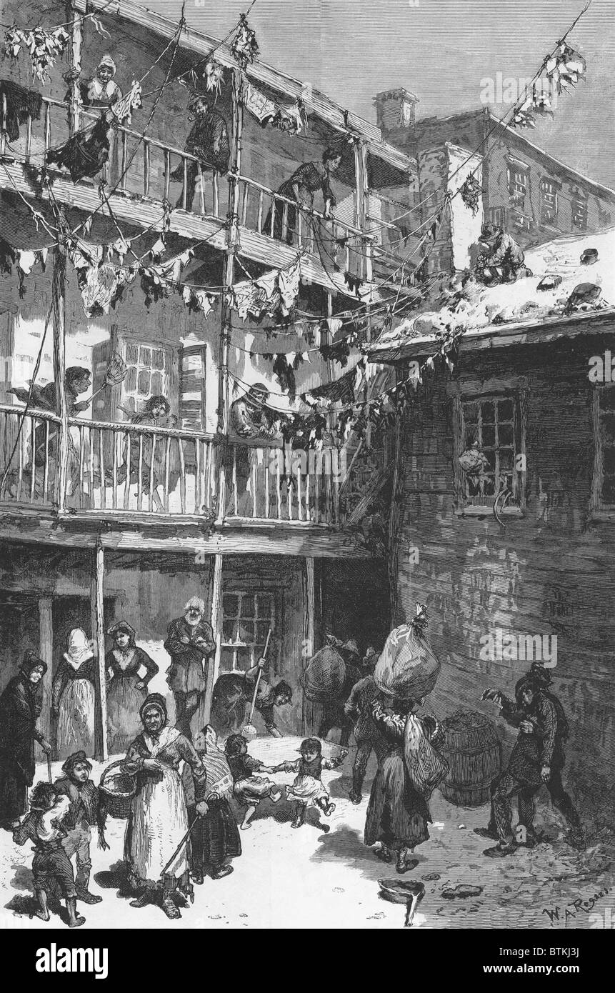 Rag Picker's court, Mulberry Street, 1879. Many poor immigrants started at the bottom of the economic ladder, as rag pickers, who collected useable refuse for reprocessing, essentially recycling in an economy of scarcity. At lower right men carry bundles collected rags. Above, laundered rags are hung out to dry after cleaning. Stock Photo