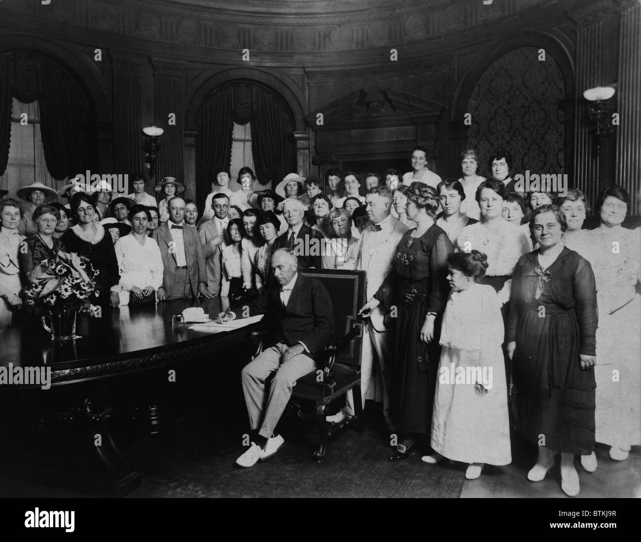 A room full women and a few men witness Governor Frederick Gardner signing Missouri's ratification of the 19th Amendment. Missouri was the 11th state of the required 36 to ratify. January 6, 1920. Stock Photo