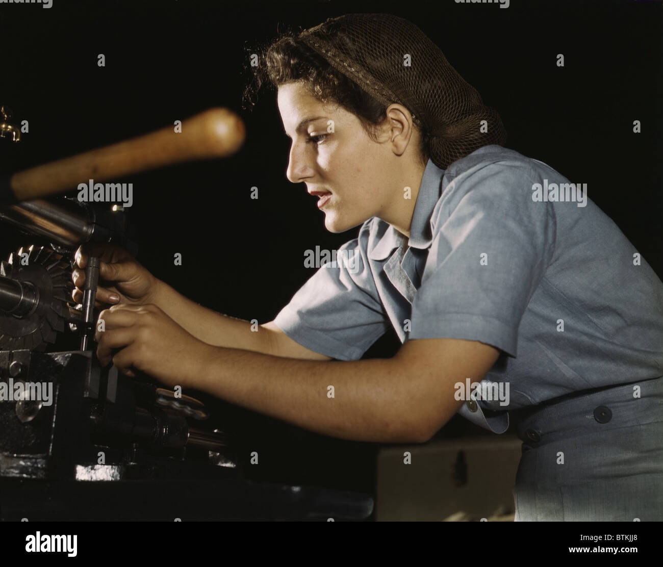 Women war worker finishing airplane parts in a hand mill at
