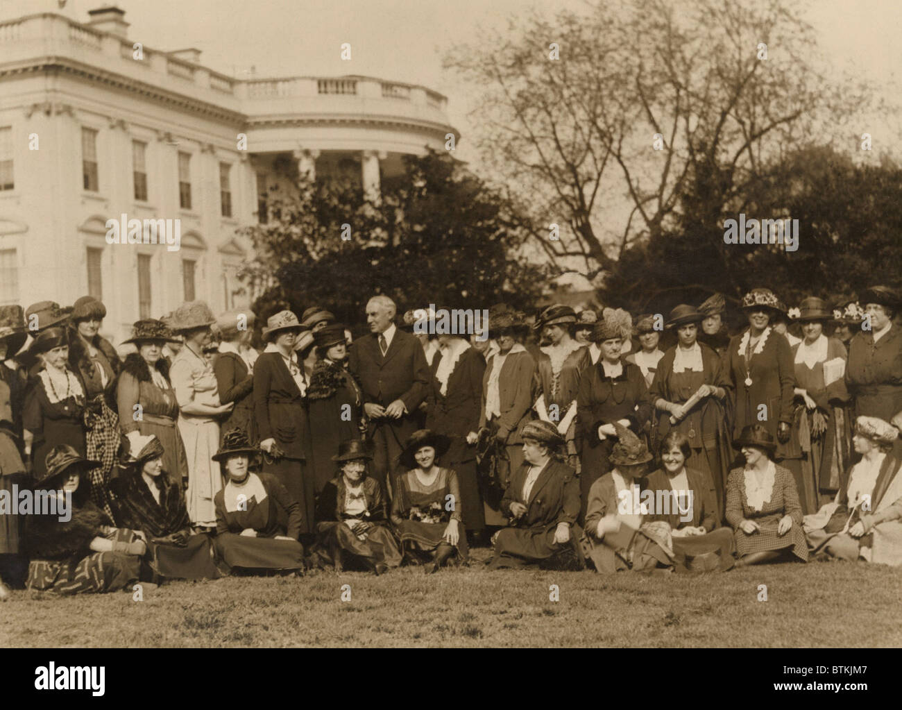 National Woman's Party members with President Harding on the lawn in front of the White House. The women ask the president's aid in passing an 'Equal Rights Bill' in the next Congress. The bill they proposed would give married women citizenship and equal rights of inheritance and contract. Stock Photo