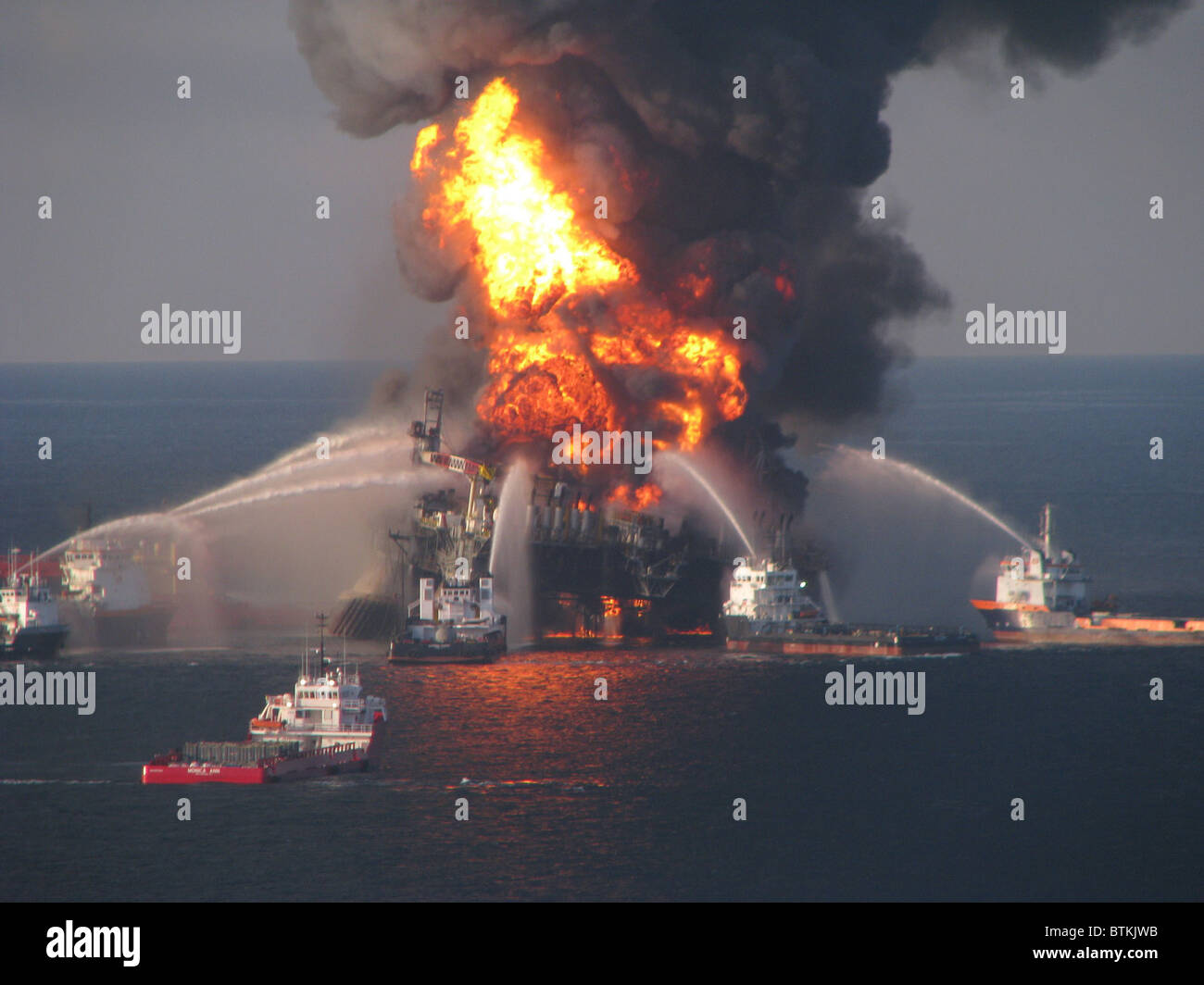 British Petroleum (BP) Oil Company's Deepwater Horizon, the offshore drilling rig is surrounded by U.S. Coast Guard fire boats on April 21, 2010. 11 workers were killed and mile deep gusher polluted the Gulf of Mexico for months. Stock Photo
