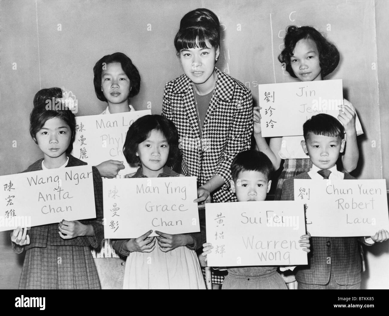 Six Chinese children who recently arrivals from Hong Kong and Formosa, hold placards giving their Chinese name in both Chinese ideographs and transliteration, plus the American style name to be entered upon the official school records. 1964. Stock Photo