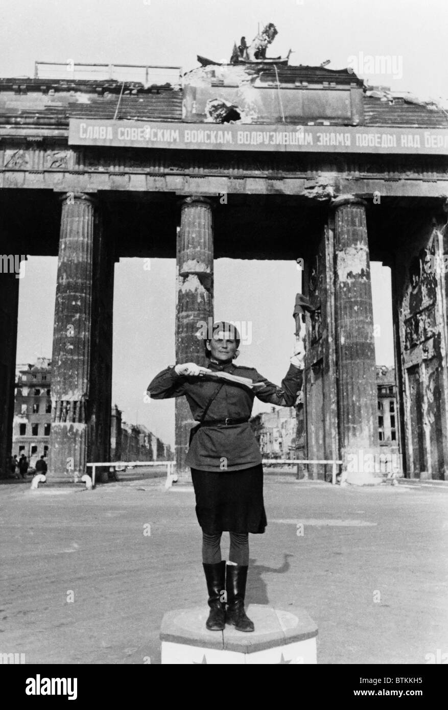 Soviet military police woman directing traffic at the Brandenburg Gate, in the Soviet Sector of divided Berlin, after the Nazi's surrendered in 1945. Photo by Evgenii Khaldei, famed Red Army photographer. Stock Photo