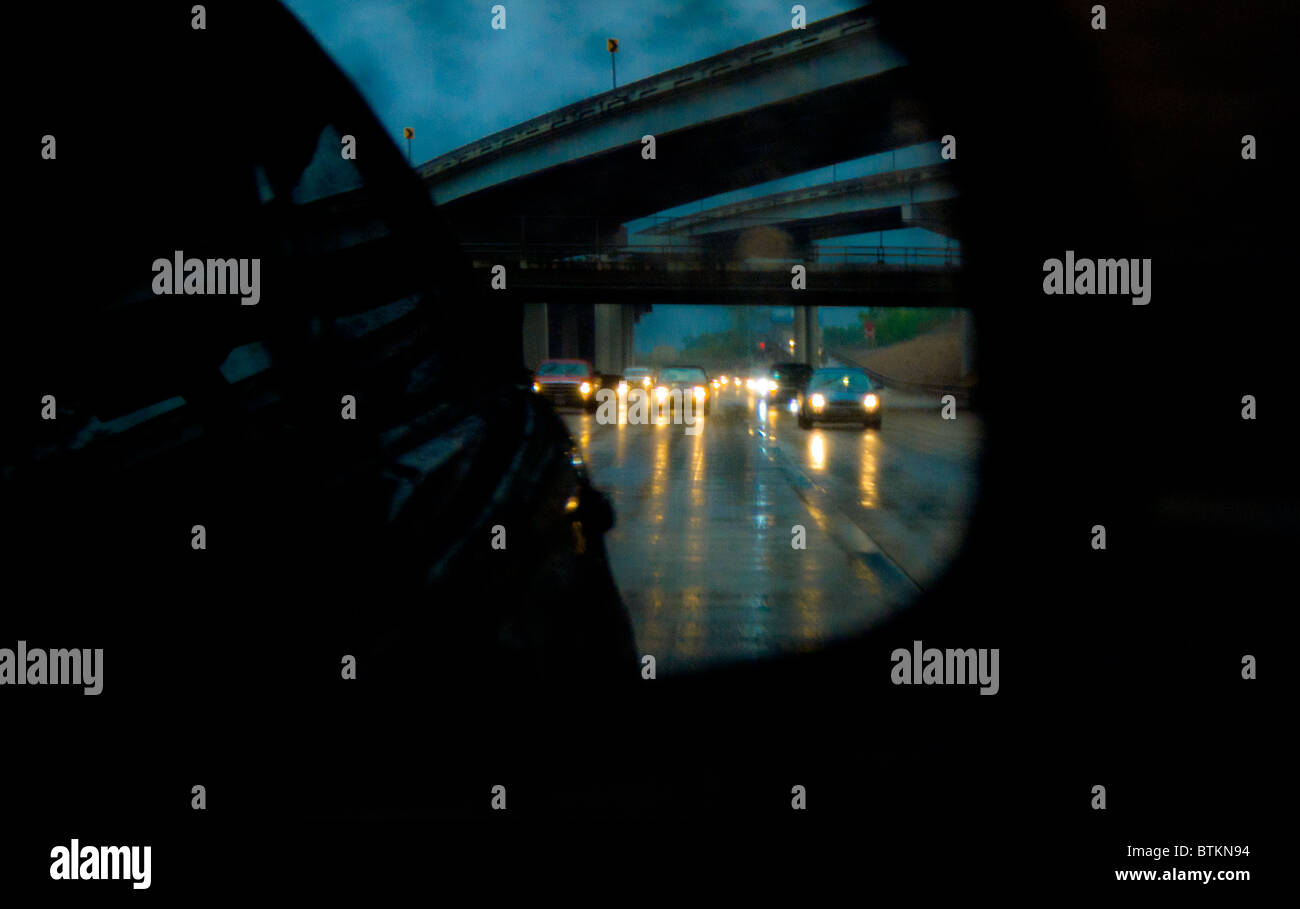 Freeway traffic reflected in car rear view mirror during torrential rain storm in Houston, Texas, USA Stock Photo