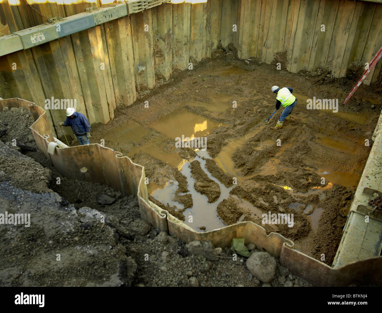 Construction Workers Preparing Hole For Petroleum Storage Tanks At Gasoline Petrol Station Stock Photo