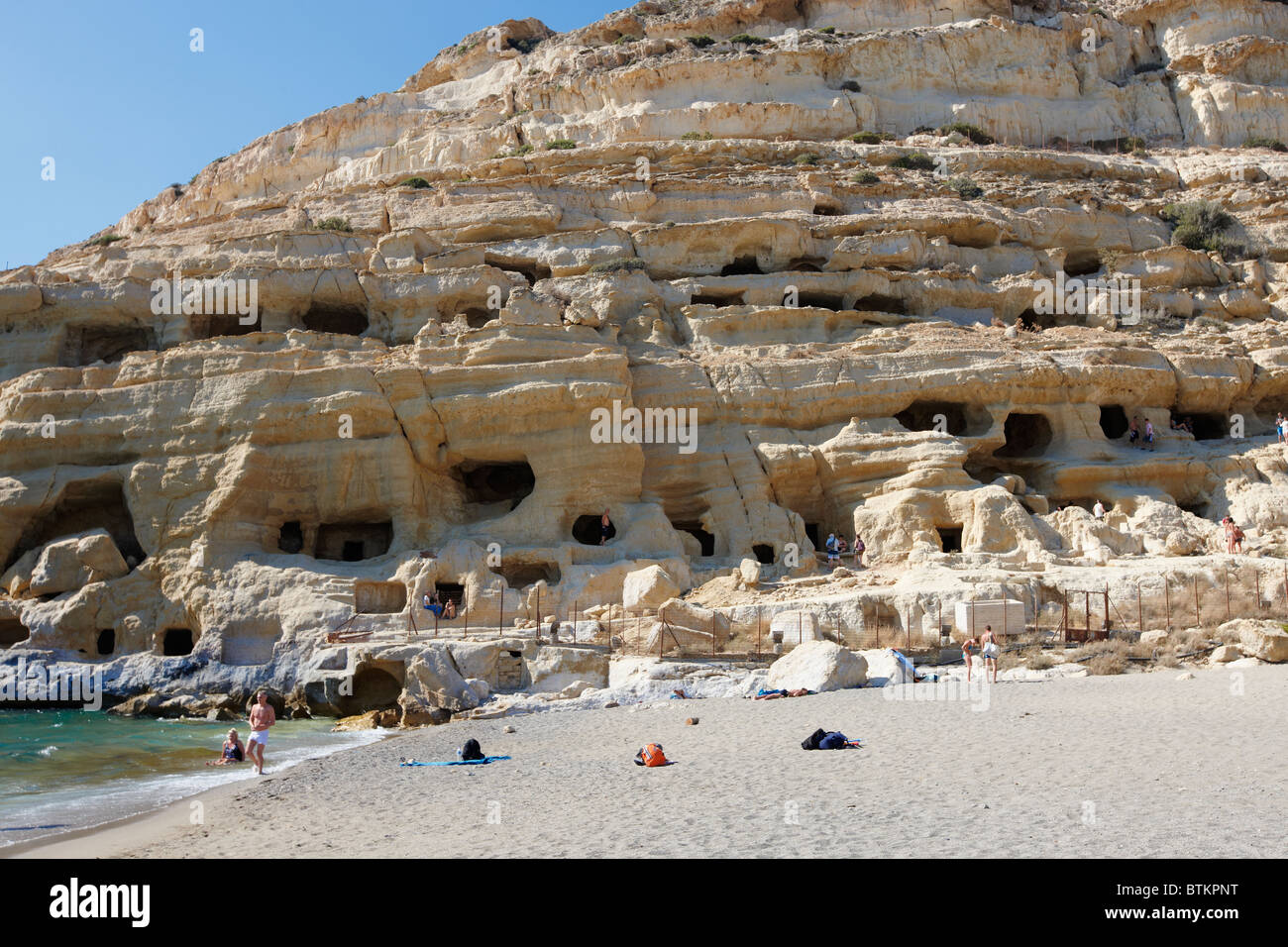 Prehistoric man-made caves carved out of the rock at Matala Beach. Matala village, Crete, Greece. Stock Photo