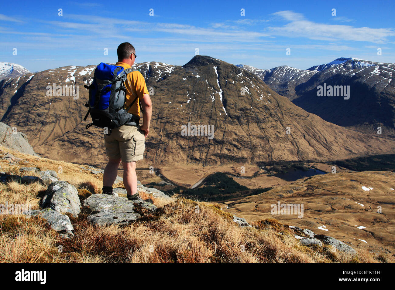 Hillwalker on Beinn Maol Chaluim looking across the mountains in Glen Etive. Stock Photo