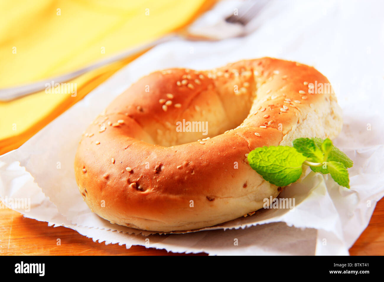 Bagel topped with sesame seeds on a paper bag Stock Photo