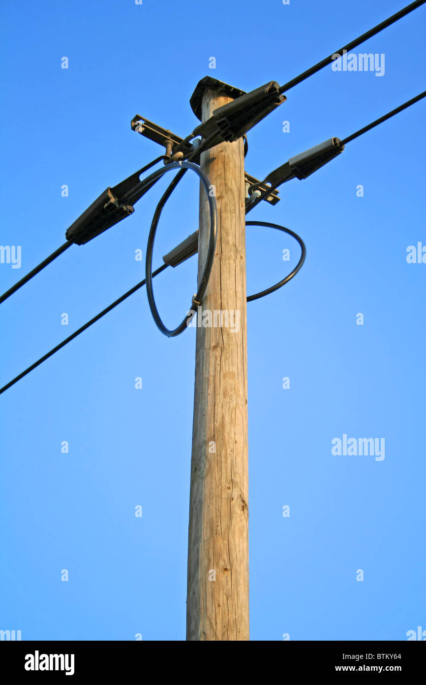 A power supply line in front of a bright blue sky Stock Photo - Alamy