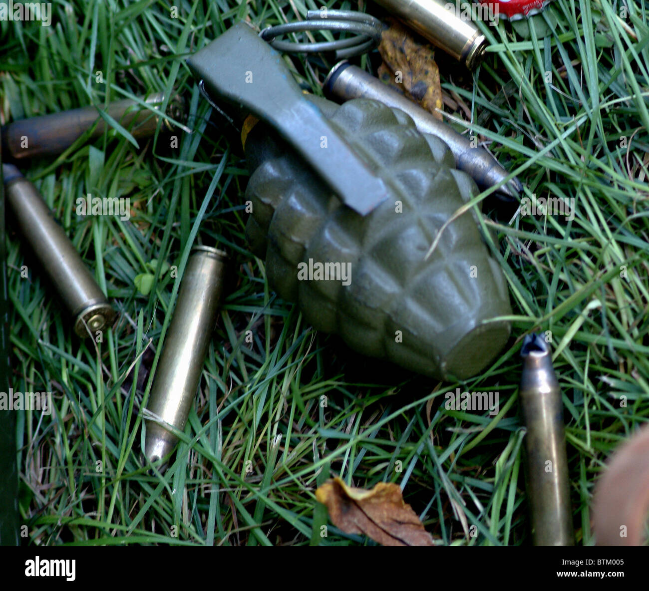 hand grenade sitting amongst spent bullets Stock Photo