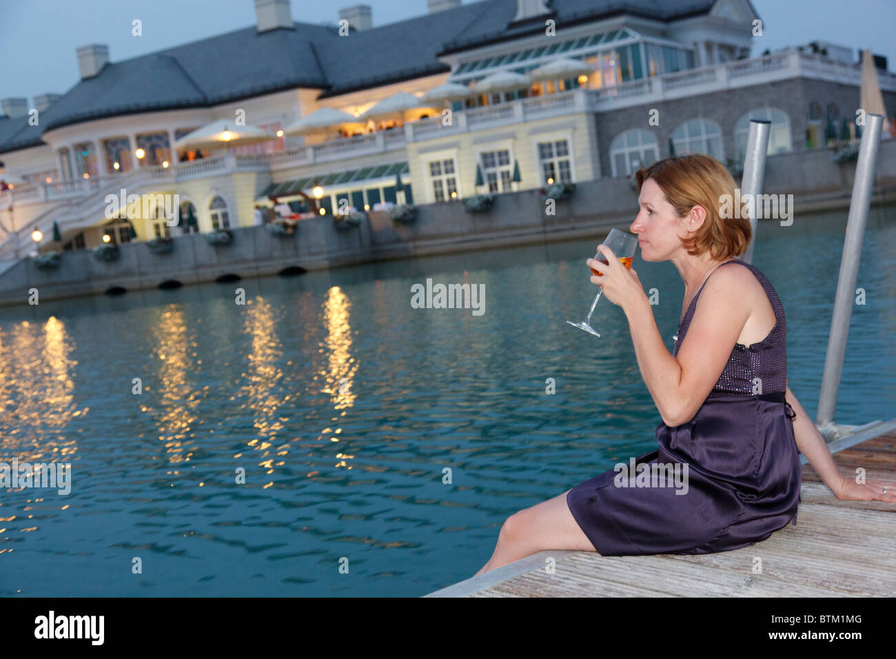 woman with Aperol Sprizz sitting on landing stage Stock Photo - Alamy