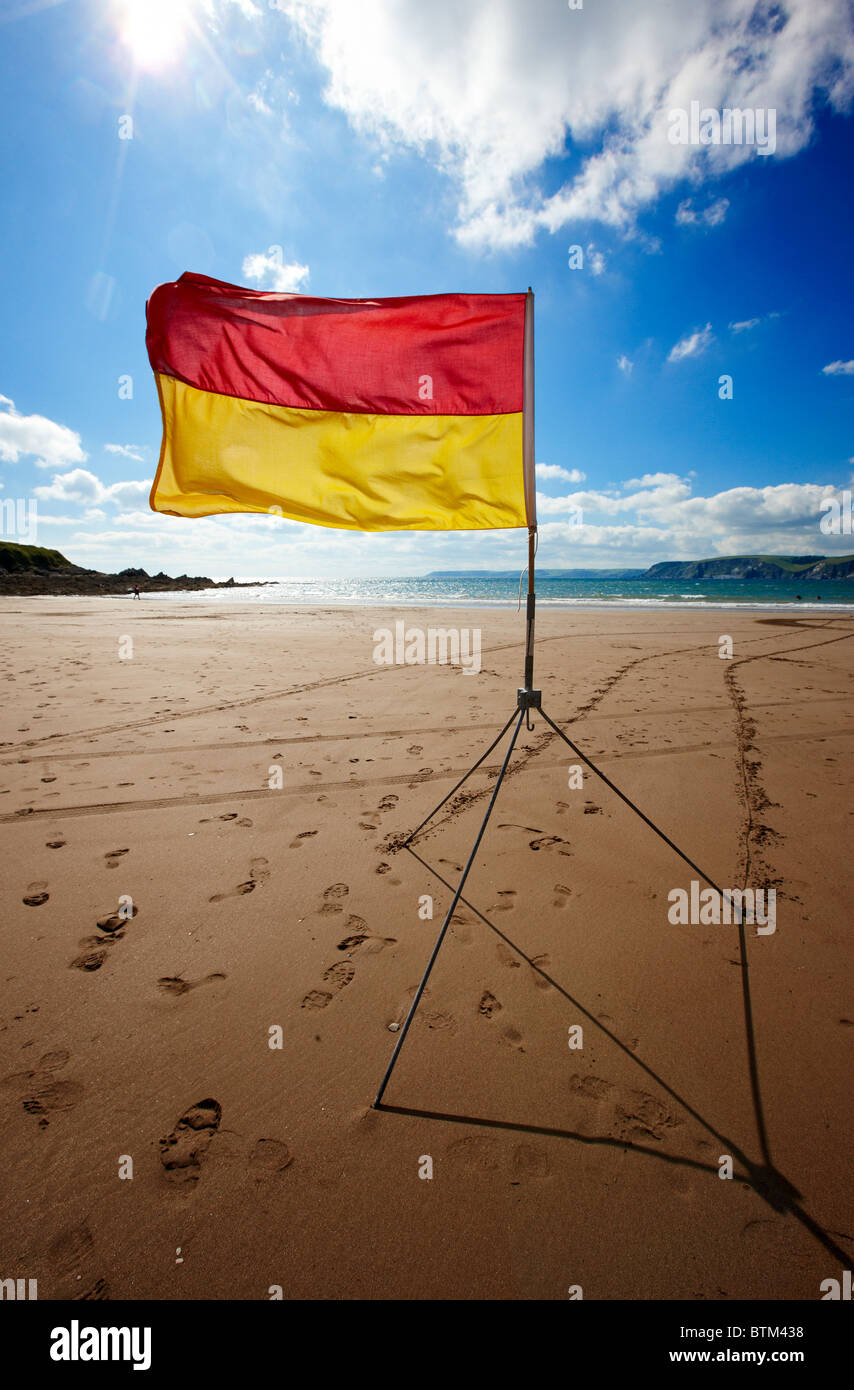 Red and yellow flag indicating area patrolled by lifeguards. Beach at