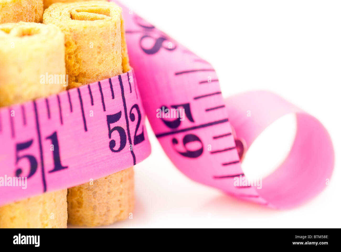 Unhealthy eating concept: Cakes rounded inch scale measuring tape. Shallow depth of field Stock Photo