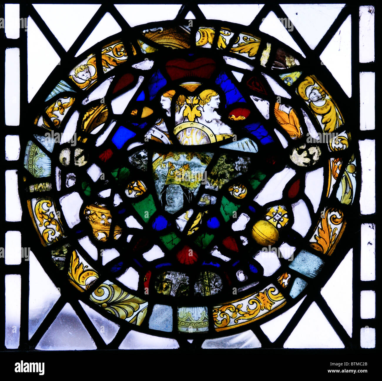 Fragments of medieval stained glass window reset into a modern window, St Michael's and All Angels Church Stock Photo