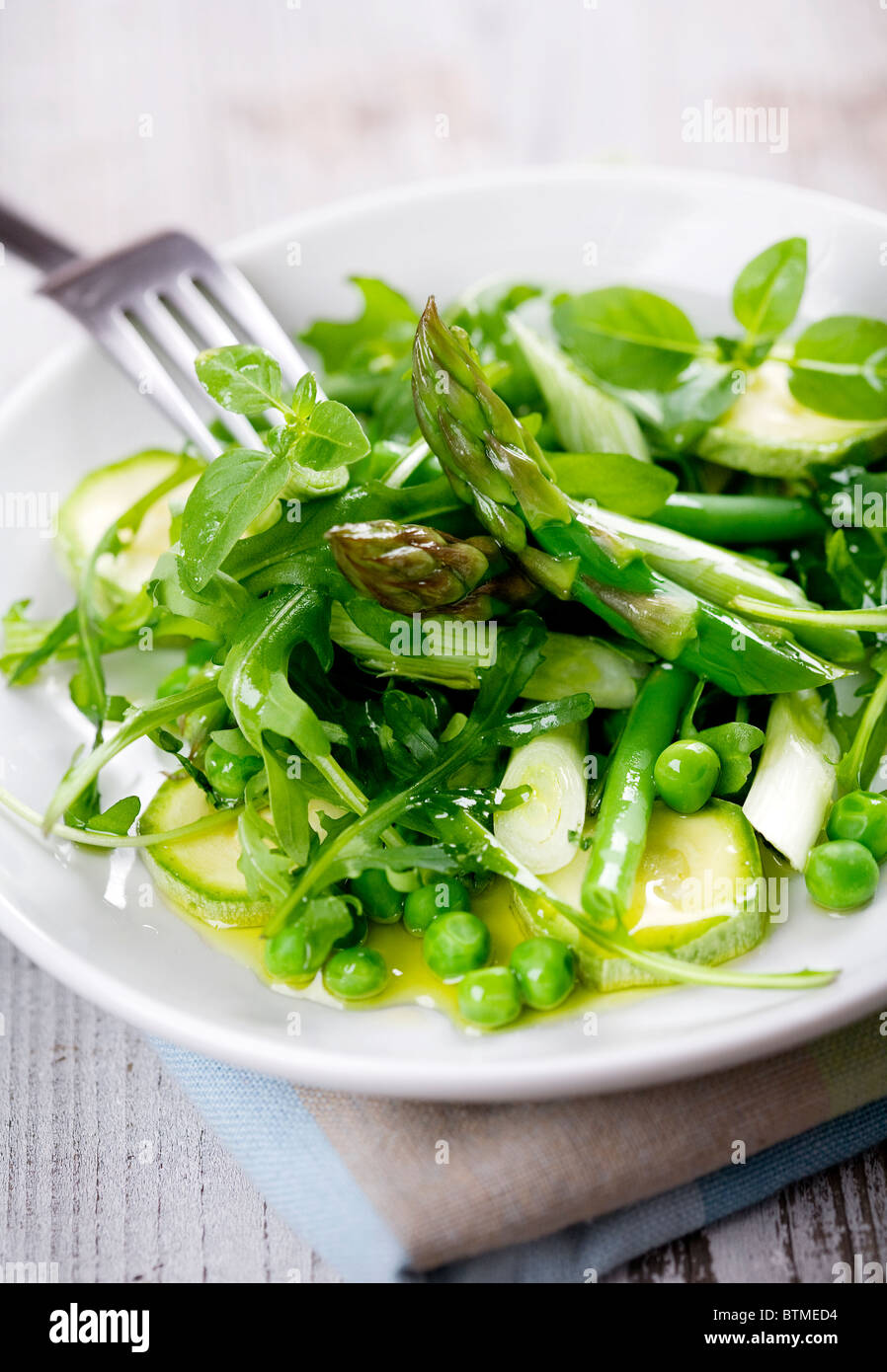 asparagus,rocket,beans,peas,zucchini,spring onions, basil, covered in olive oil Stock Photo