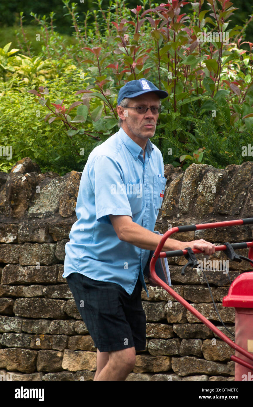 Postman delivering the mail in the Cotswold village of Broadway, UK Stock Photo