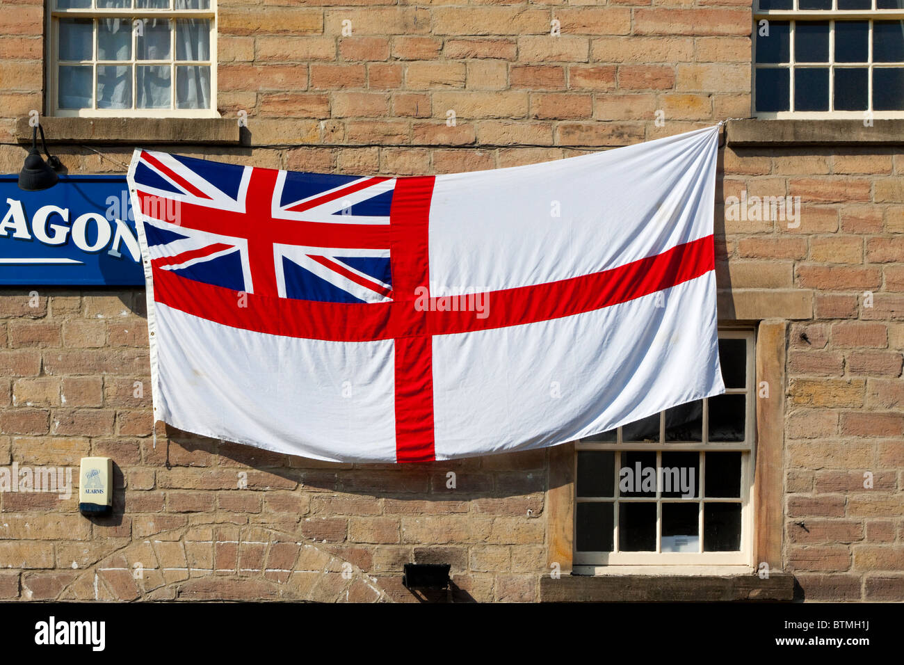 White Ensign or St George's Ensign flag normally flown on British Royal Navy ships or shore establishments seen her outside pub Stock Photo