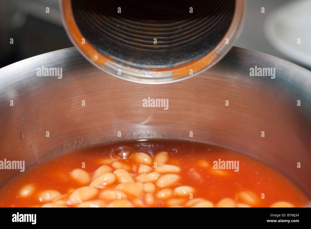 Emptied Baked Beans Can with Beans in Saucepan Stock Photo