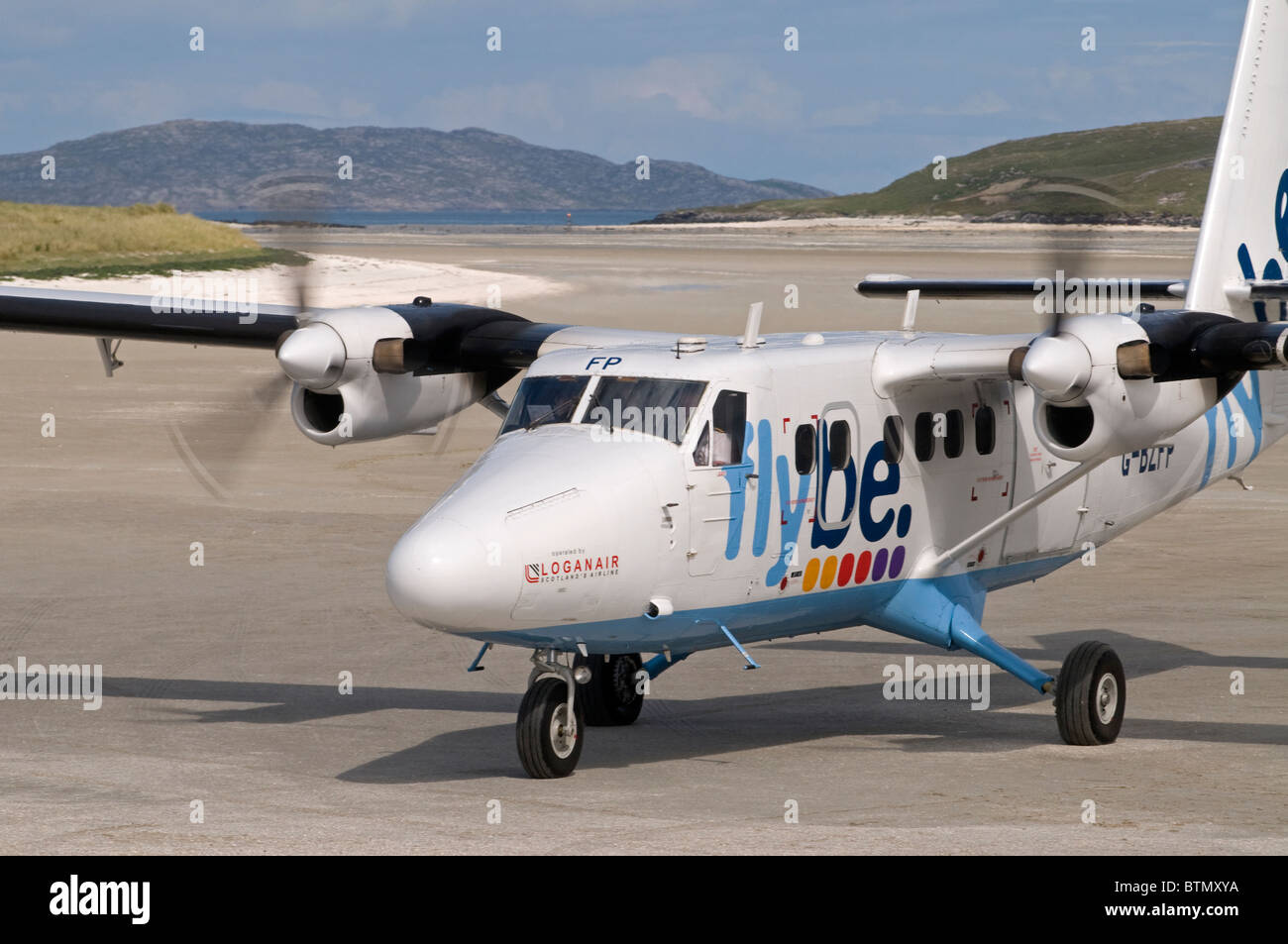 Flybe Twin Otter Aircraft arriving on the Traigh Mhor shellstrand airstrip Barra Airport, Hebrides. Scotland. SCO 6605 Stock Photo