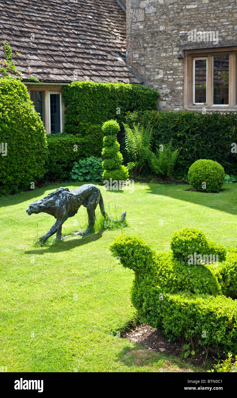 Corner of an English country garden with topiary and garden art. Stock Photo