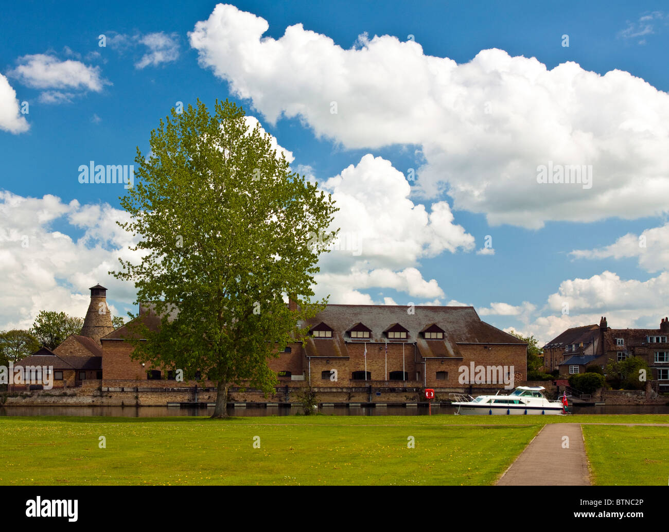 A Motor Boat on a river in St Neots Cambridgeshire with a building in the background Stock Photo