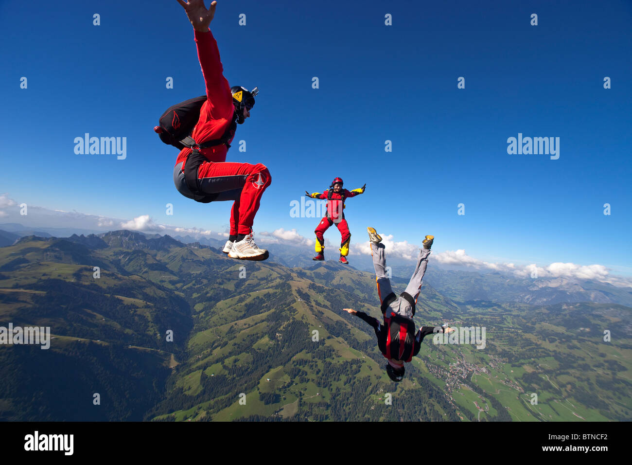 Skydiver are flying head up within a team in the sit fly position over ...
