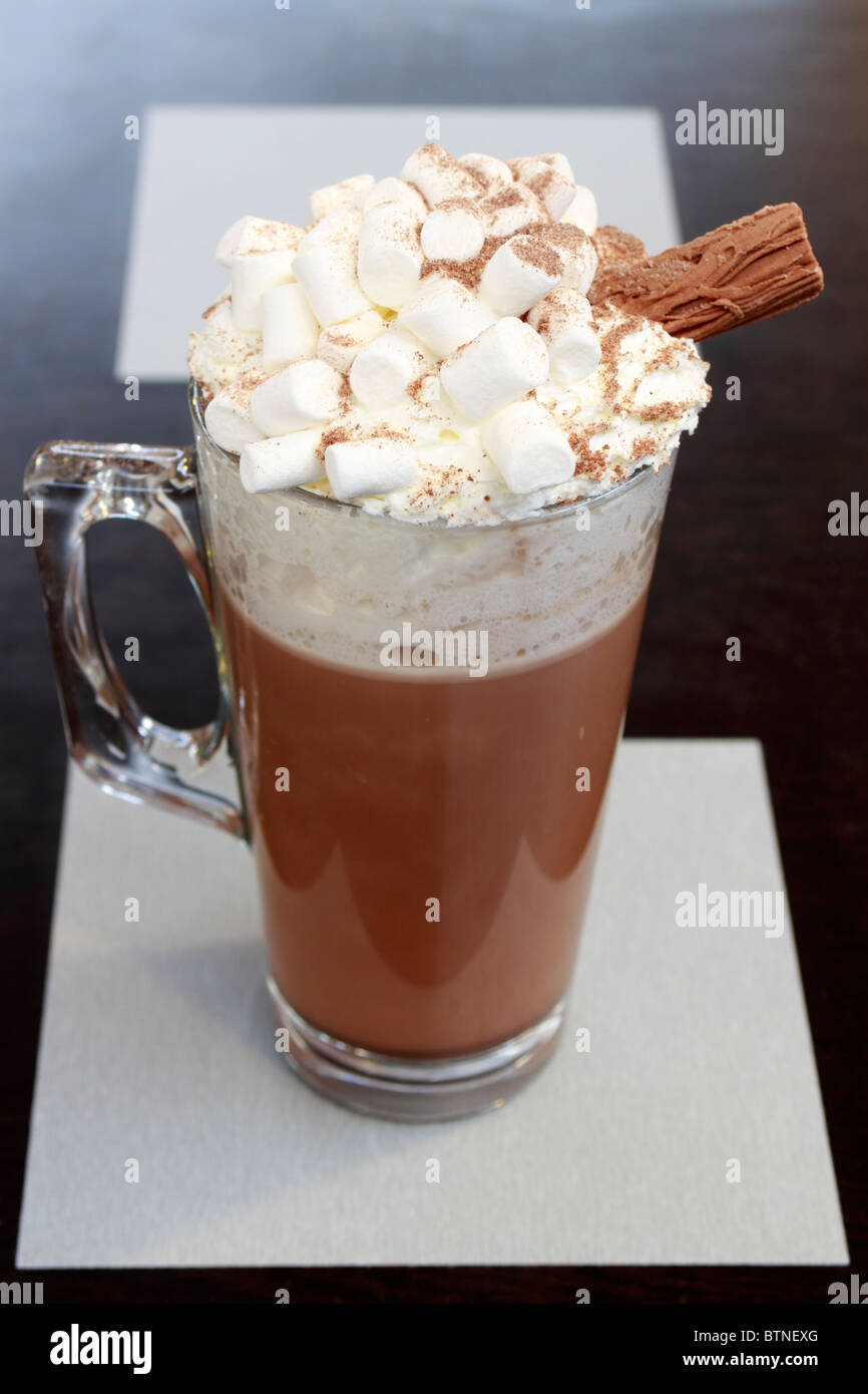Mug of Hot chocolate with marshmallows, cream and a stick of chocolate Stock Photo