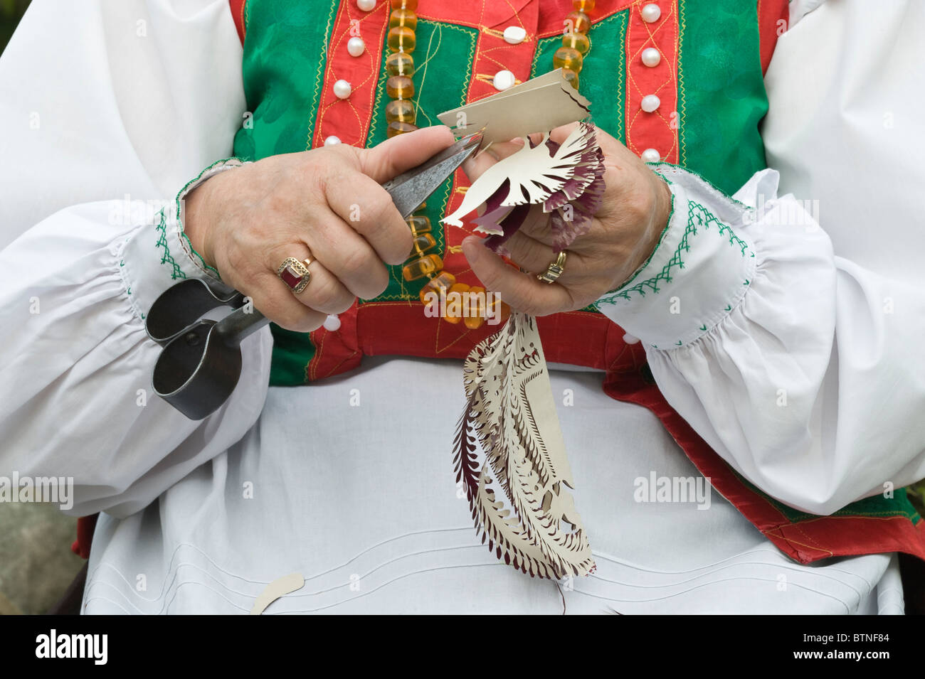 Apolonia Nowak folk artist from Kurpie Region Poland using sheep shearing scissors to make traditional paper-cutting Stock Photo