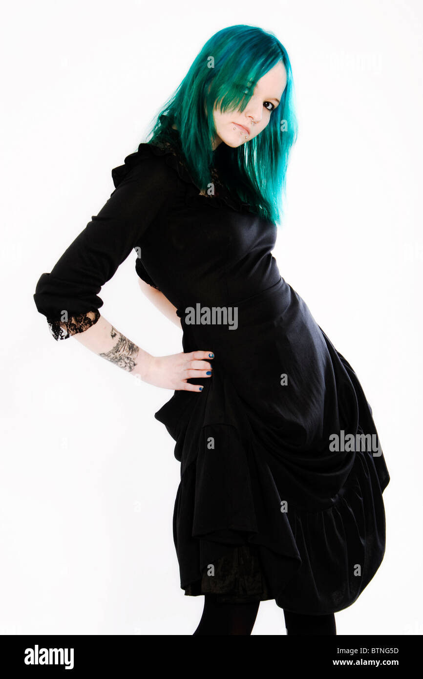 A young goth woman with green hair wearing a black dress. Stock Photo