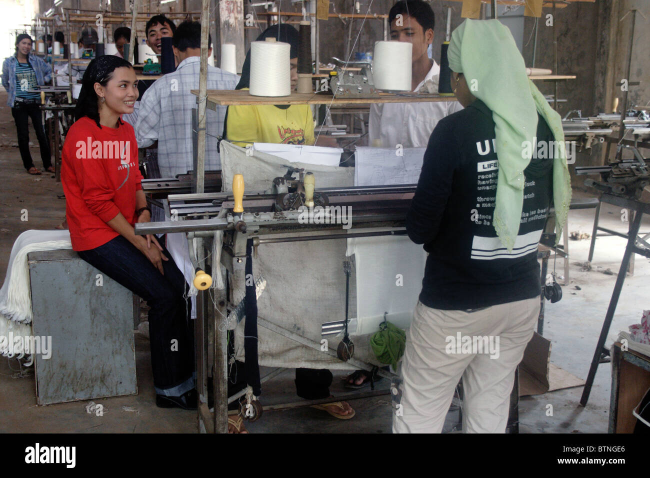 Young Khmers work at their machines in a Chinese owned garment factory near Kampong Cham, Cambodia. Stock Photo