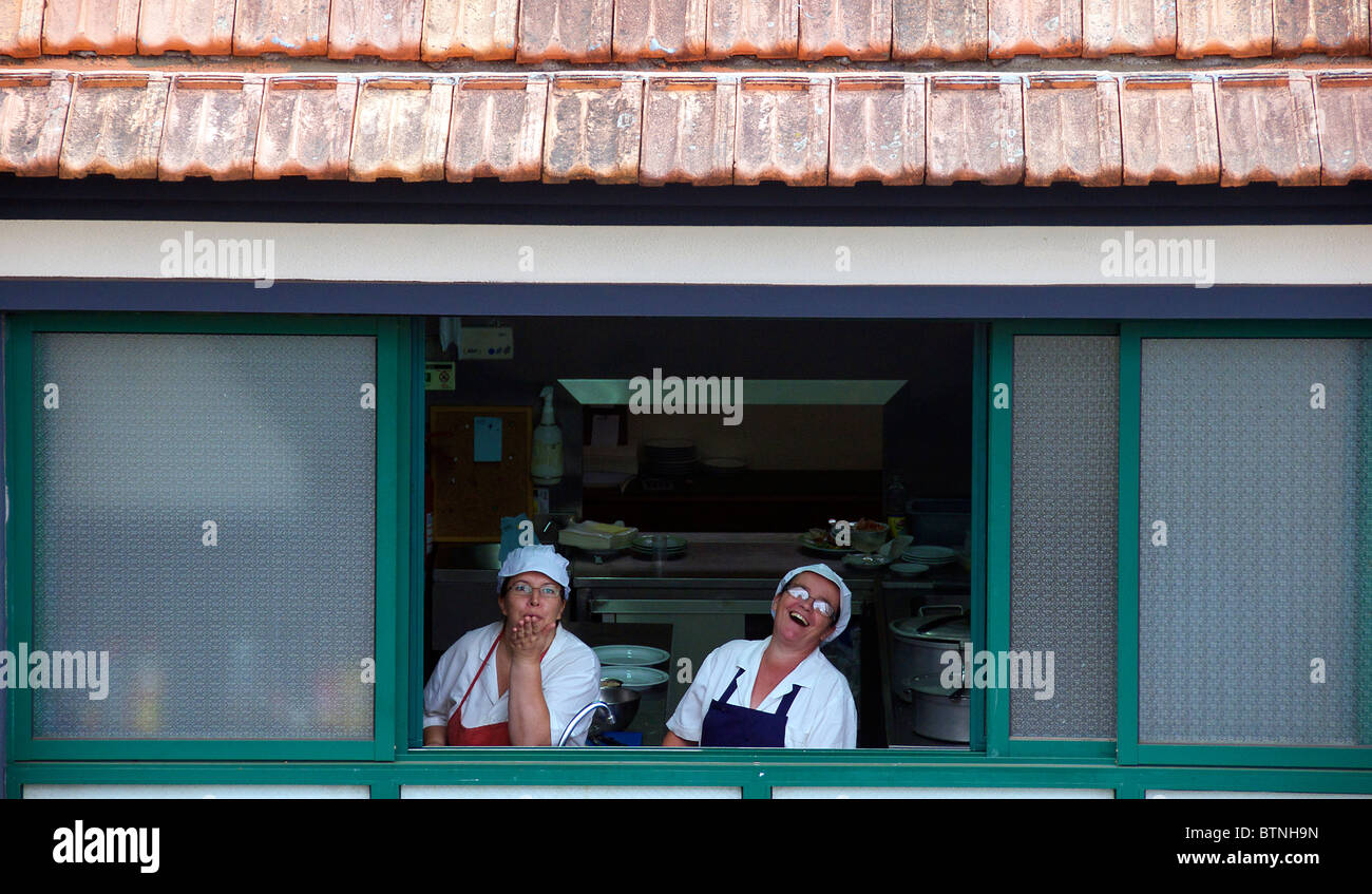 Two kitchen staff laughing from window Monte Funchal Madeira Portugal Stock Photo