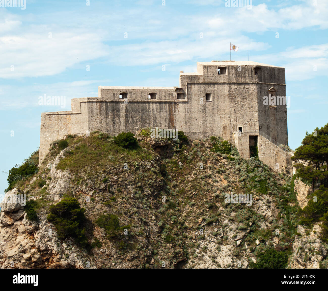 Ancient fortress on the cliff edge of Dubrovnik protects the port Stock Photo