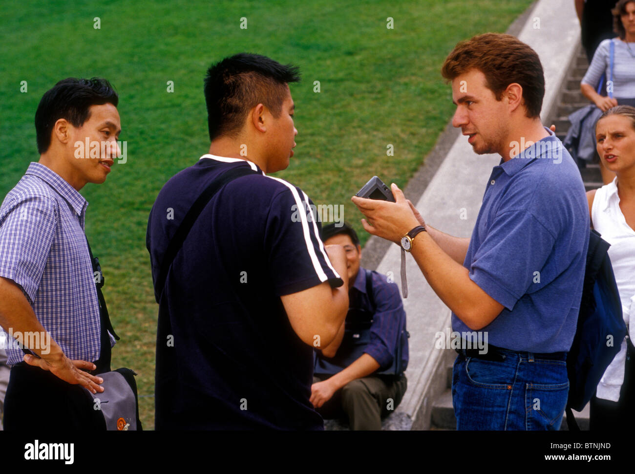people, tourists, asking a question, asking for help, taking photo, taking photograph, Paris, Ile-de-France, France, Europe Stock Photo