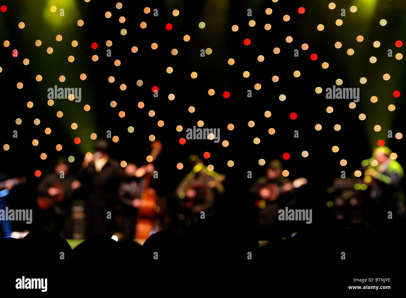 abstact music stage with multicolored lights and crowd silhouettes ...
