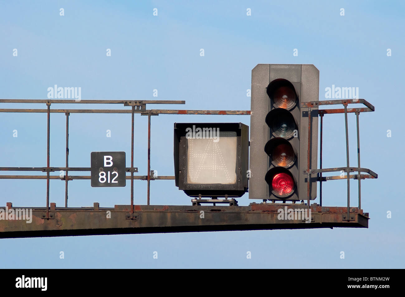 Railway gantry with a red stop light Stock Photo