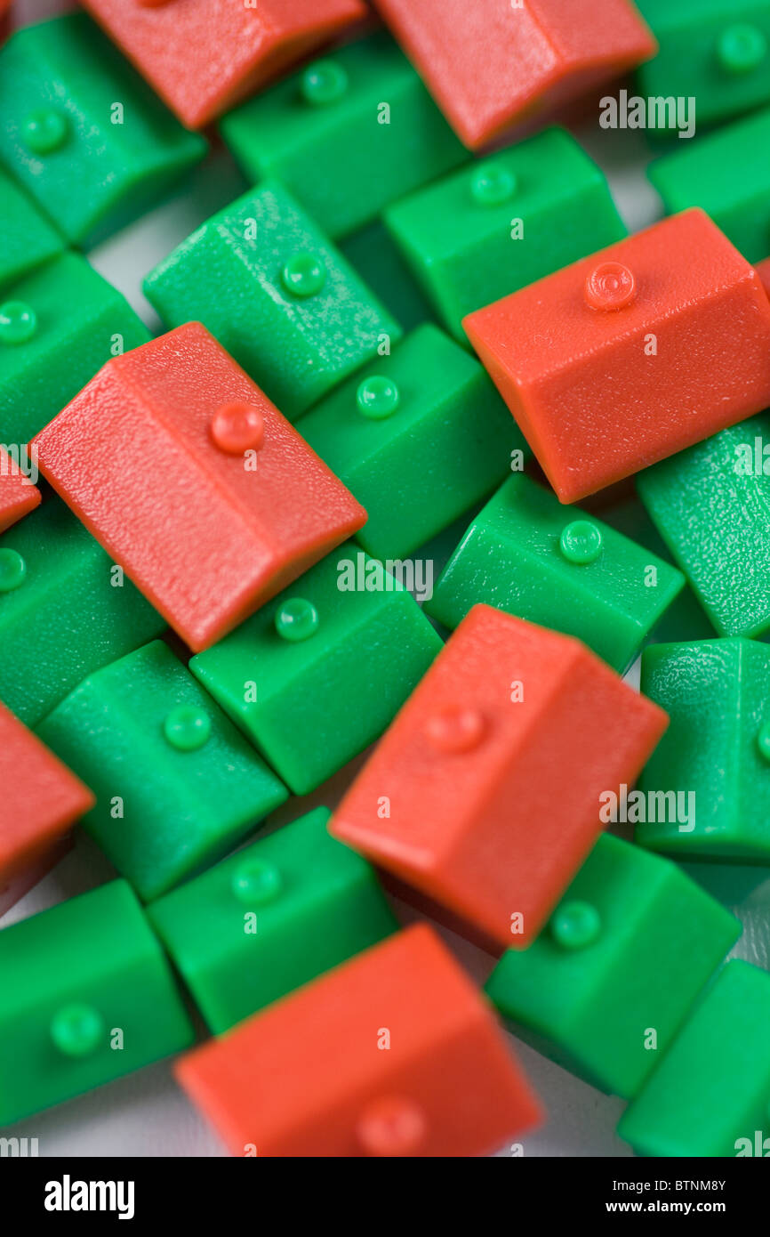 Mixed red and green Monopoly houses crammed together. Stock Photo